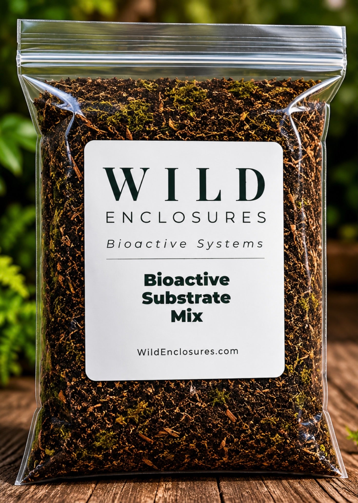 Bag of Wild Enclosures Bioactive Substrate Mix displayed on a natural wood surface with a blurred terrarium-style background. This nutrient-rich substrate blend is designed for bioactive terrariums, vivariums, isopods, springtails, reptiles, amphibians, and tropical enclosure setups.