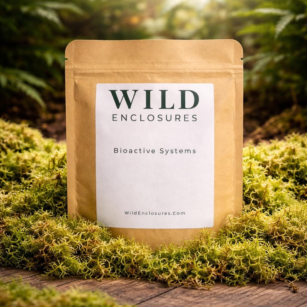 Kraft stand-up pouch labeled “Wild Enclosures – Bioactive Systems” displayed on a wooden surface surrounded by natural moss in a forest-style setting.